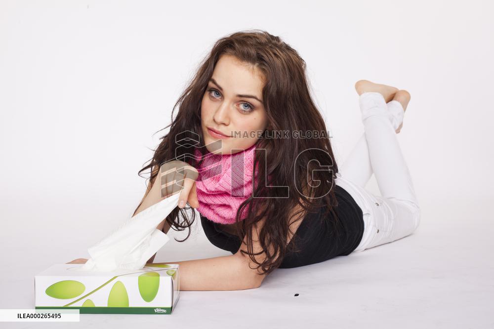 A beautiful young woman, lady, girl, cold, runny nose, headache, tissues, paper hankies, scarf, handkerchiefs, handkerchief, nose-blowing