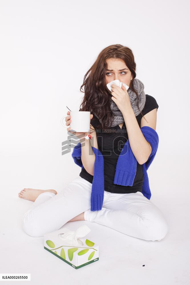 A beautiful young woman, lady, girl, cold, runny nose, headache, tissues, paper hankies, cup of tea, scarf, handkerchiefs, handkerchief, nose-blowing