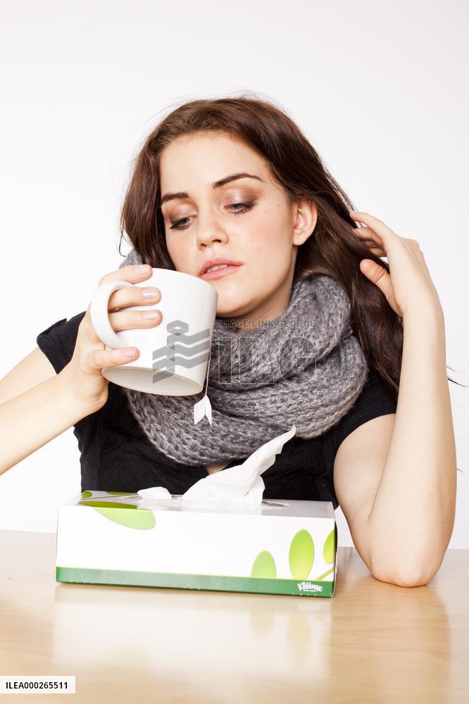 A beautiful young woman, lady, girl, cold, runny nose, headache, tissues, paper hankies, cup of tea, scarf, handkerchiefs, handkerchief
