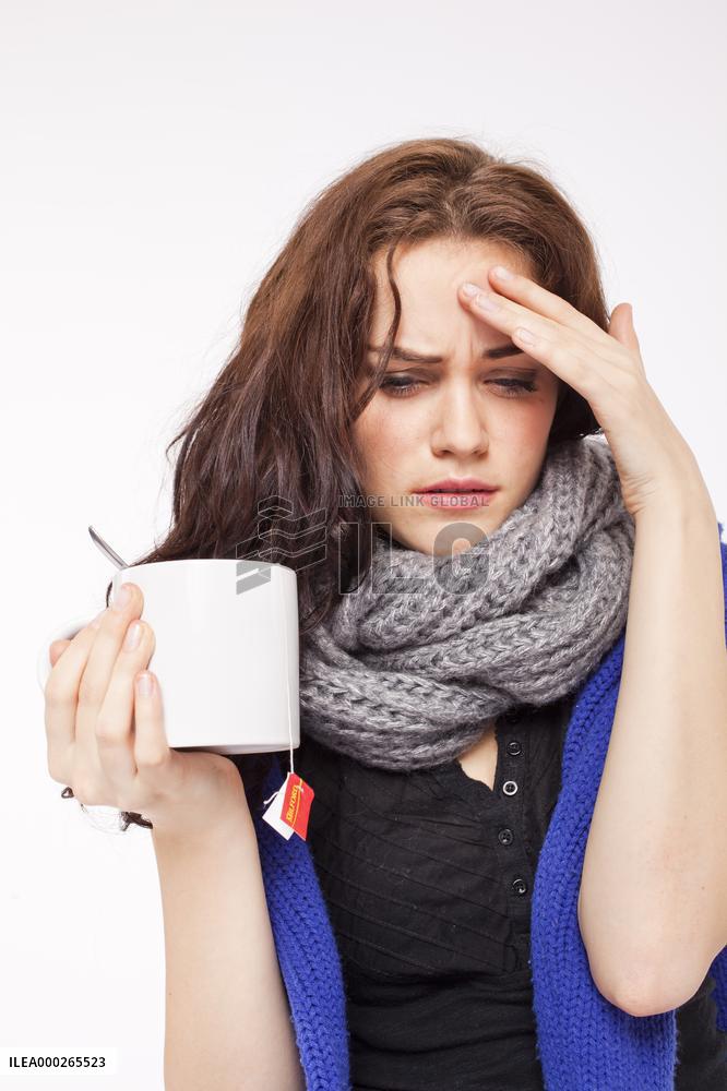 A beautiful young woman, lady, girl, cold, runny nose, headache, cup of tea, scarf, hot drink