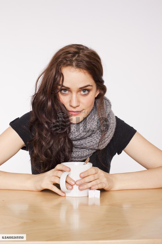 A beautiful young woman, lady, girl, cold, runny nose, headache, cup of tea, scarf, hot drink