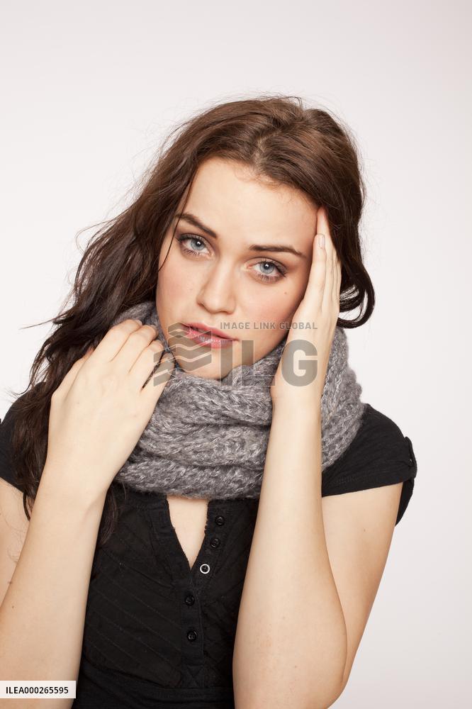 A beautiful young woman, lady, girl, cold, runny nose, headache, scarf