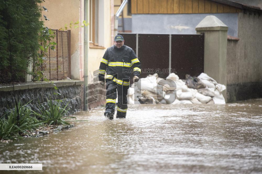 River Novohradka, village Luze, heavy rain, raised water level, fireman, bags with sand