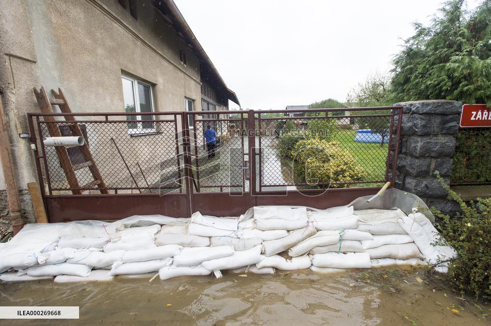River Novohradka, village Luze, heavy rain, raised water level, house, bags with sand