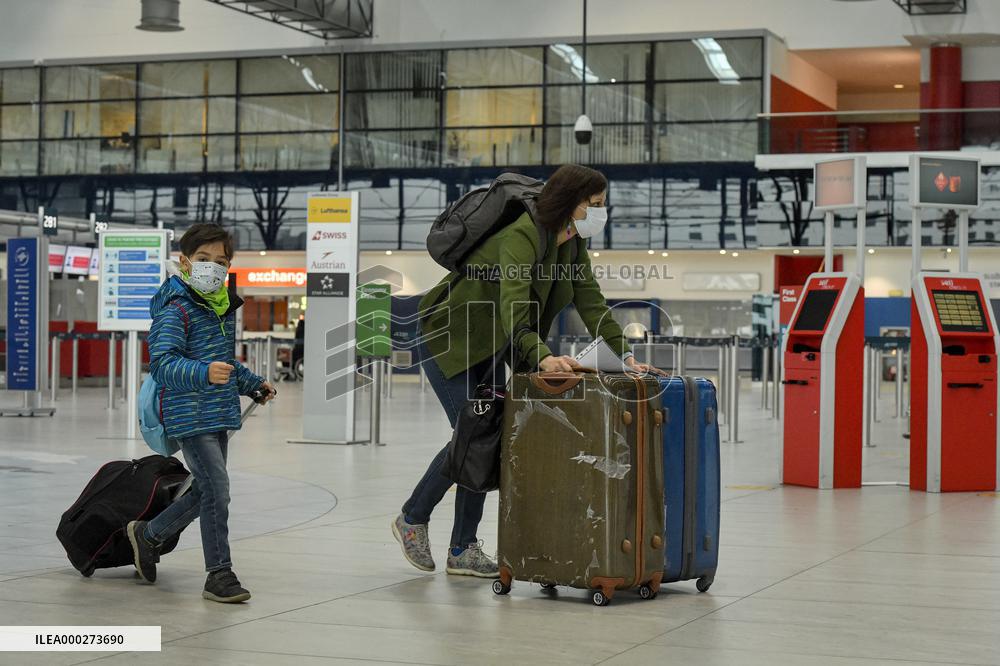 passengers in protective face masks in the departure hall of Vaclav Havel Airport Prague