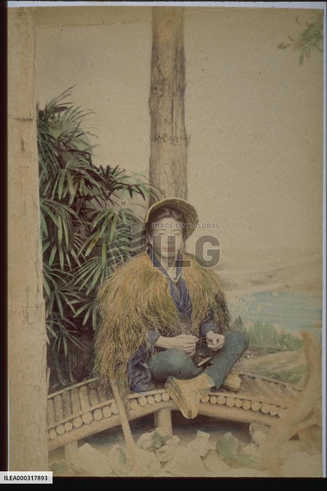 Man wearing mino,a straw raincoat