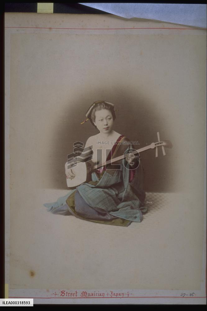 Woman playing the shamisen,japanese balalaika,with bare shoulder