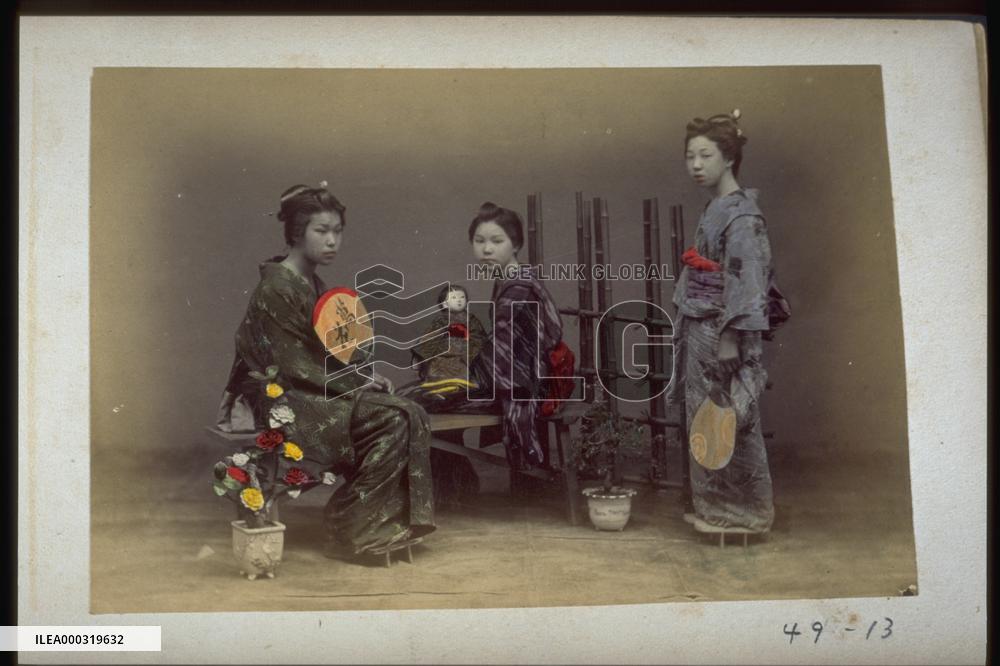 Girls holding dolls and fans