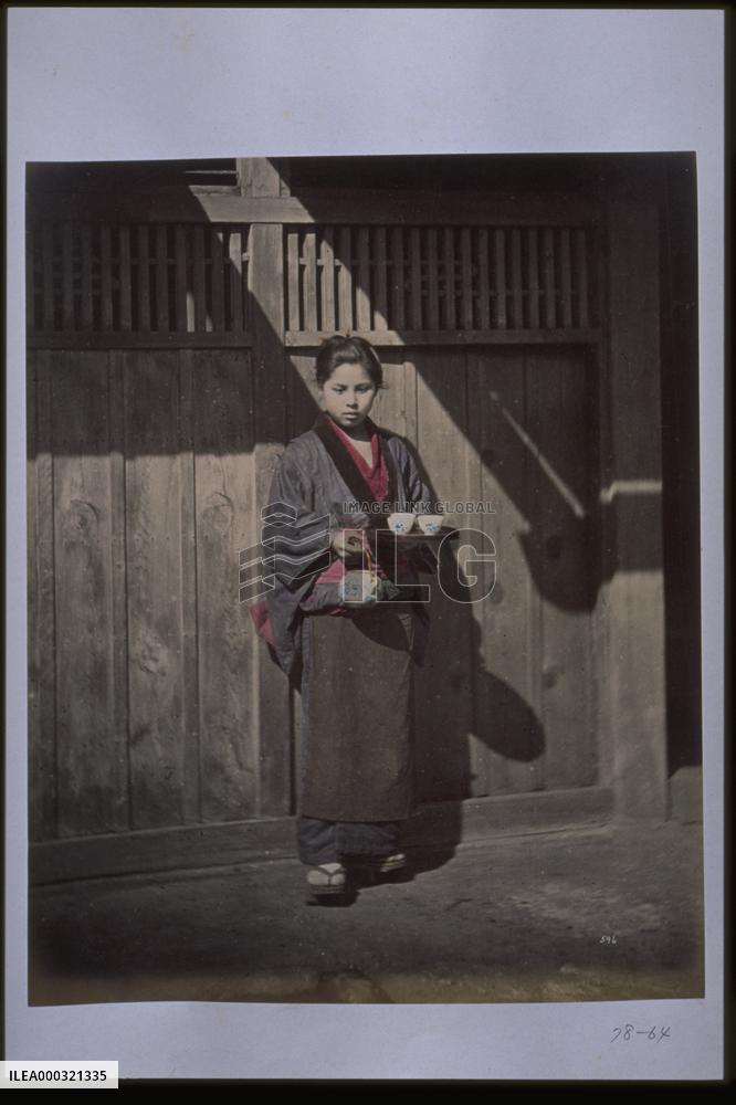 A girl holding a tea set