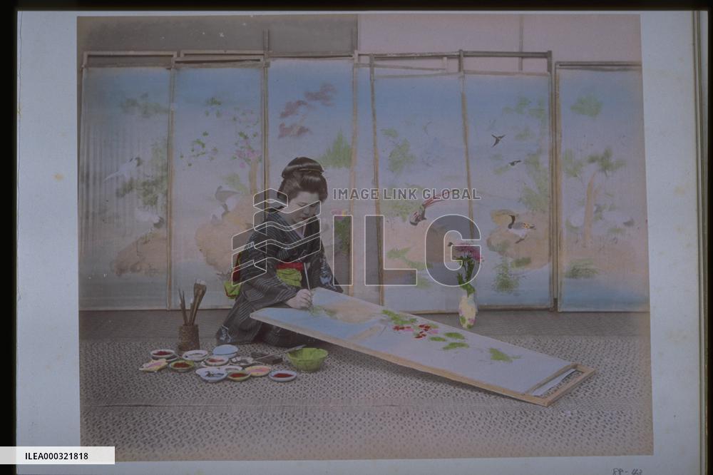 A woman painting a picture for a folding screen