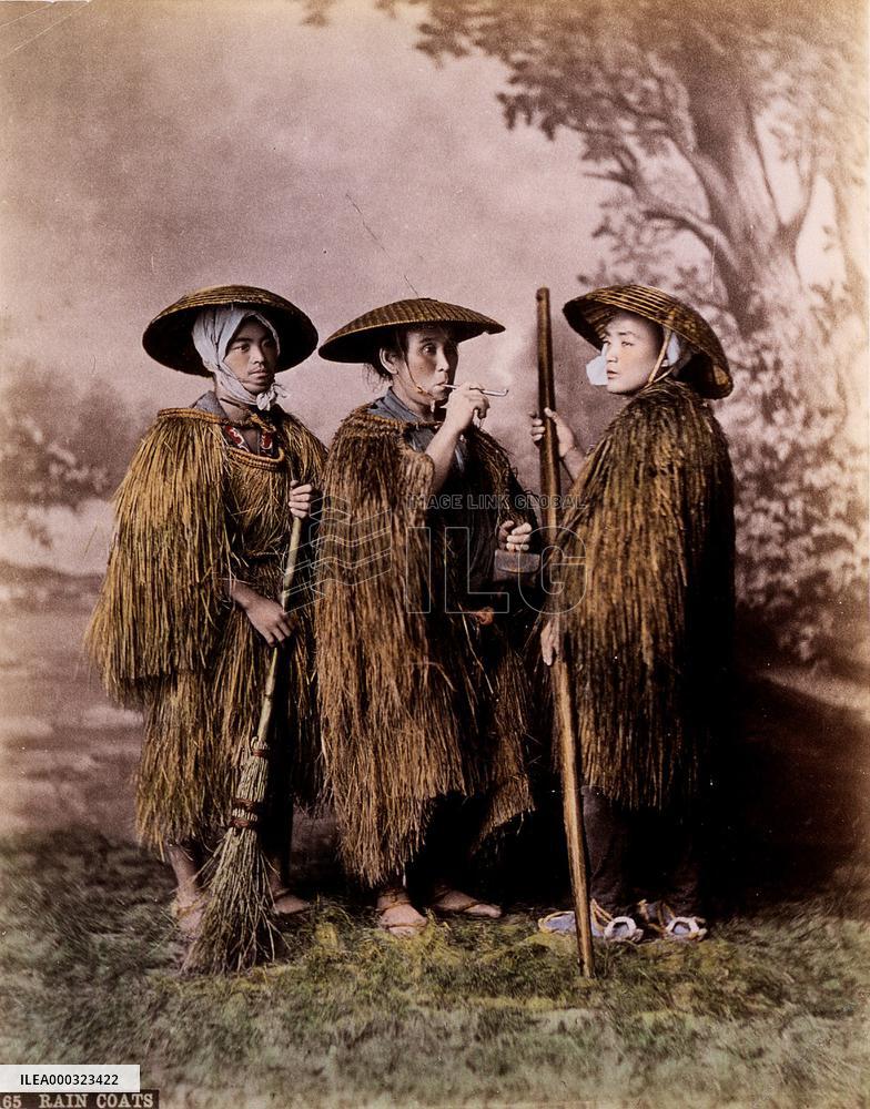 Farmers wearing straw raincoats and caps
