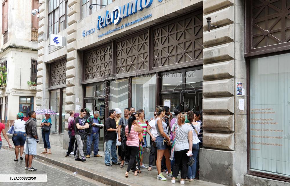 People wait in line before Havana mobile phone shop