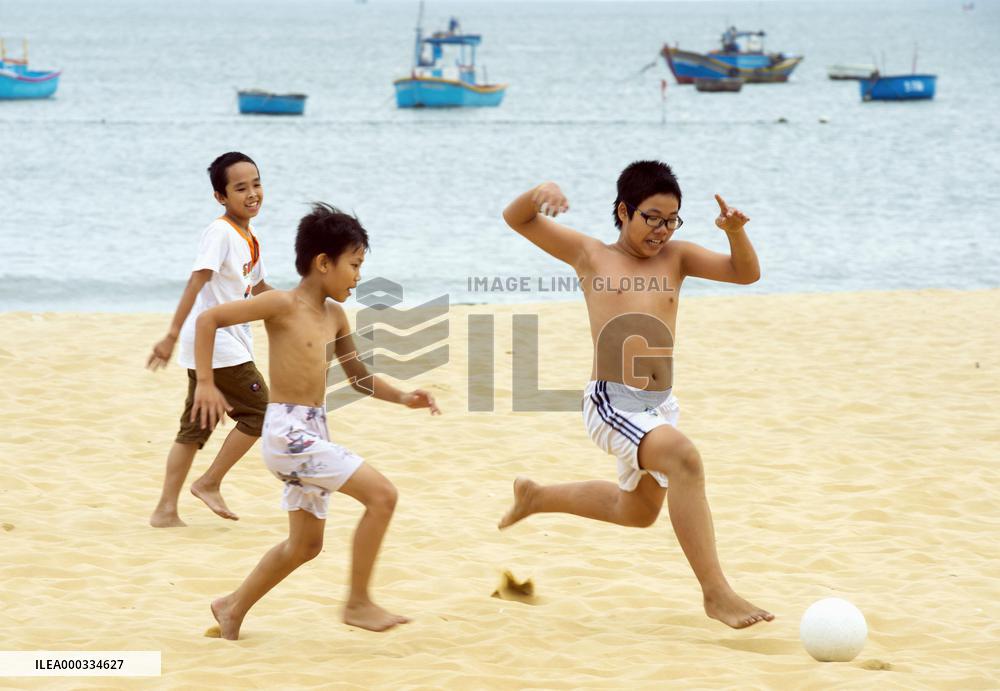 Vietnamese children play soccer on beach