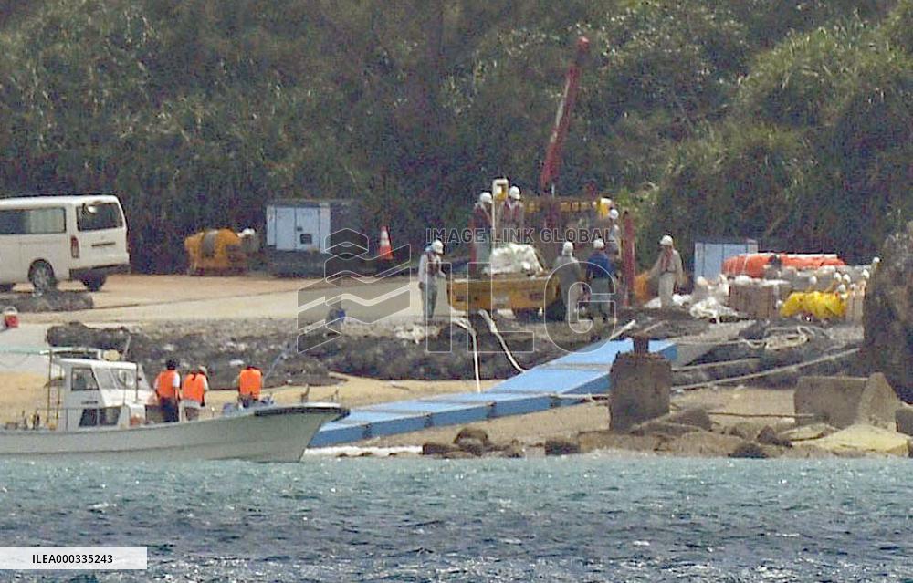 Workers unload supplies for base relocation in Okinawa
