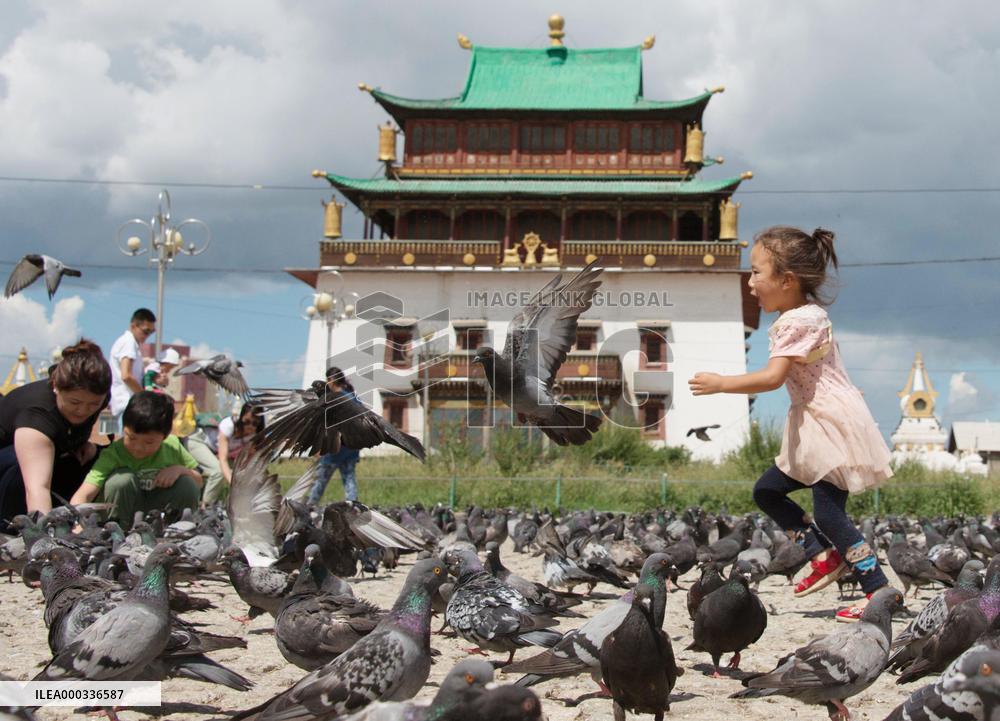Kid chases after pigeons at Ulan Bator monastery