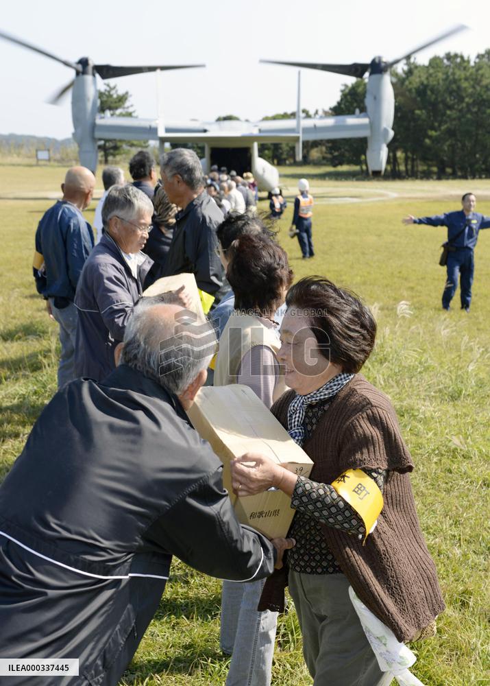 People carry relief goods from Osprey in disaster drill