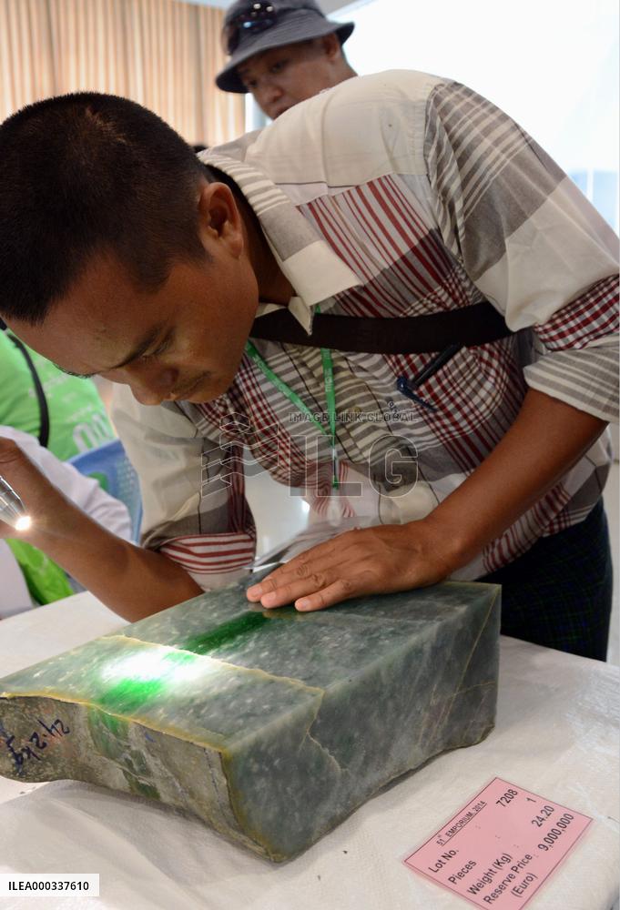 Buyer examines gemstone at Myanmar's gem emporium