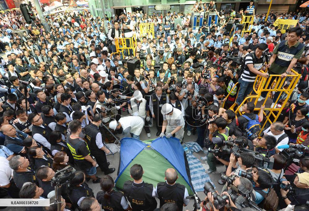 H.K. officials begin dismantling protest barricades