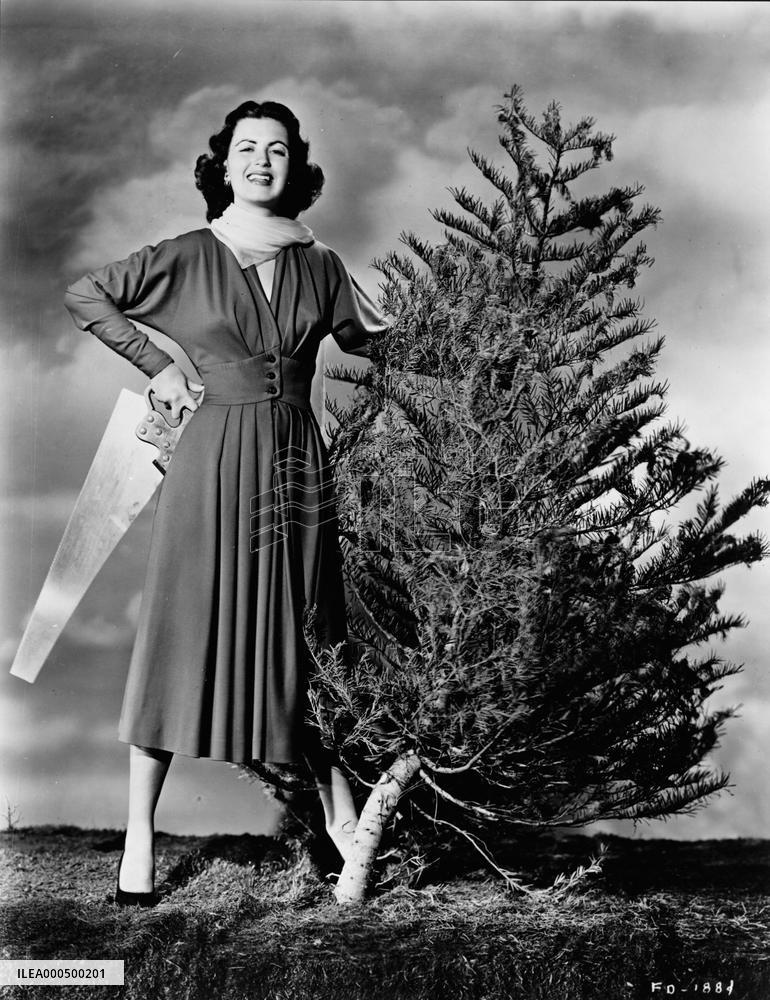 Actress FAITH DOMERGUE WITH CHRISTMAS TREE AND SAW