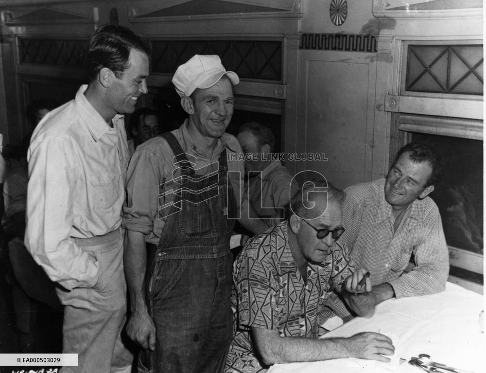 DIRECTOR JOHN FORD (SITTING IN SHORT SLEEVED SHIRT) NEXT TO