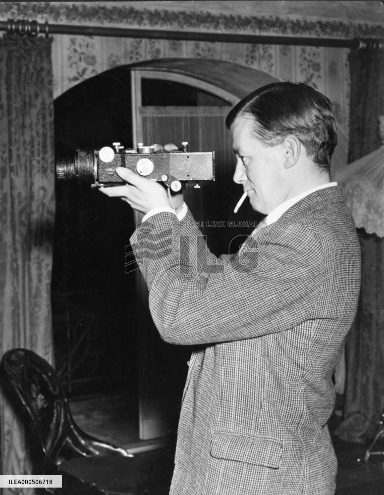 DIRECTOR ROBERT HAMER LOOKING THROUGH A VIEWFINDER ON THE SE