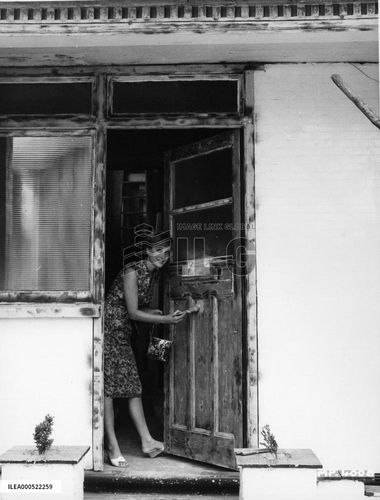 SYLVIA SYMS PAINTING HER NEW FRONT DOOR IN THE MID NINETEEN