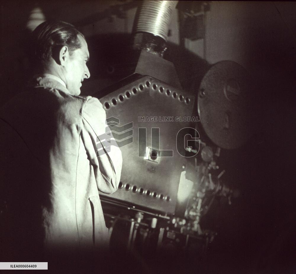 PROJECTIONIST standing by a Ross film projector 1930s / 40s