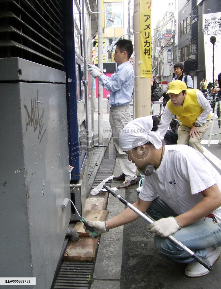 Volunteers scrub off graffiti at America Mura in Osaka