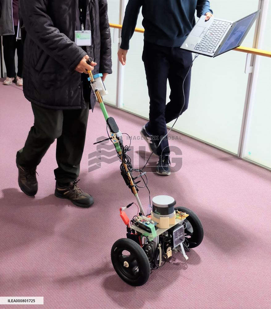 Demonstration experiment of walking guidance by a cane-type robot with wheels at Osaka City University
