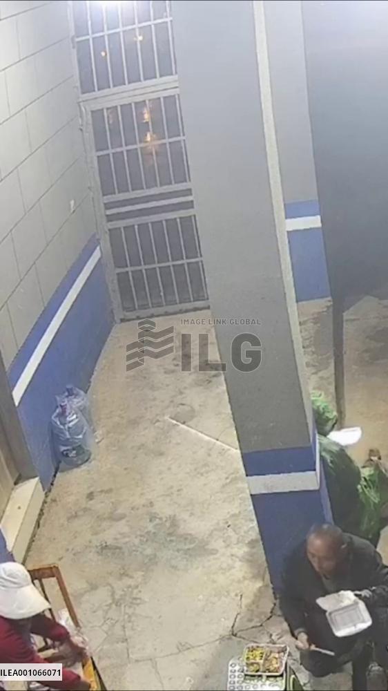 Policemen in E China provide shelter from rain for construction workers