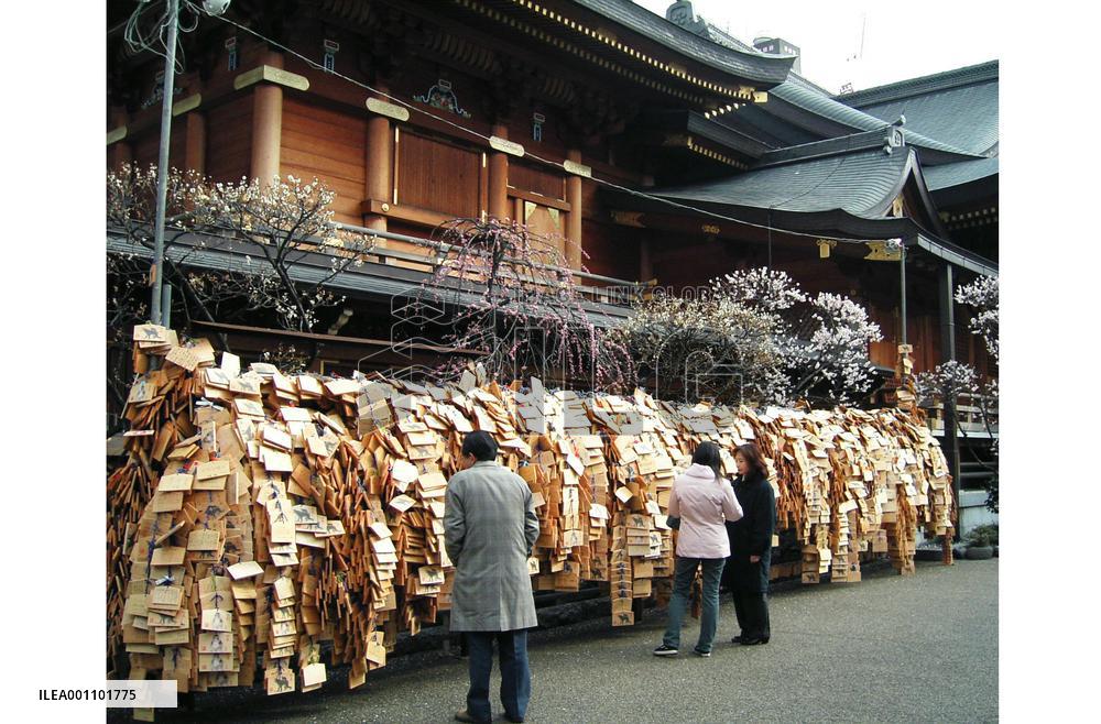 Votive tablets inscribed by university students adorn shrine