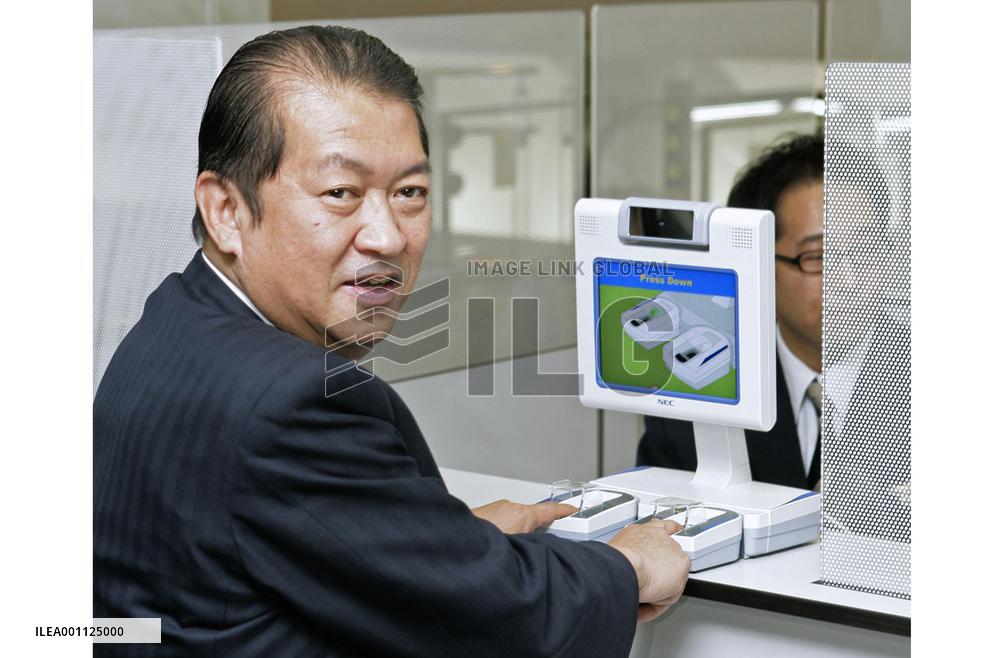 Justice minister tries out fingerprinting system at Narita