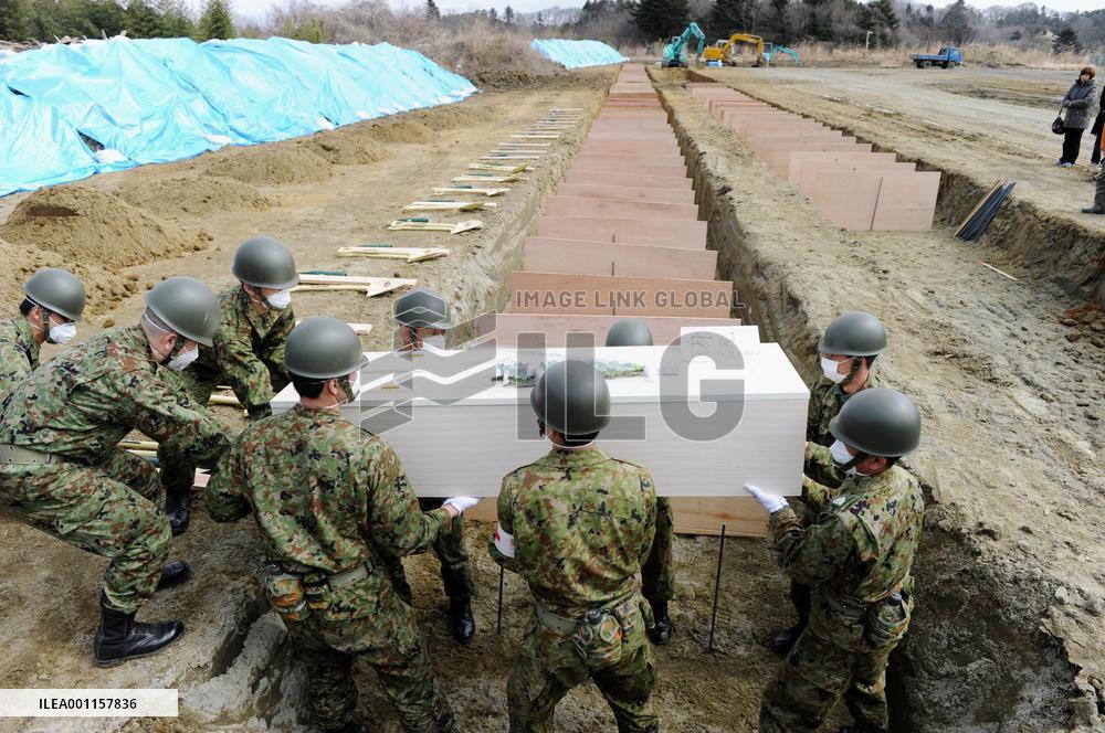 Burial of quake and tsunami victims