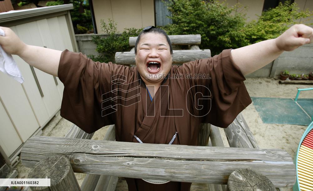 Sumo wrestler smiles broadly after promotion