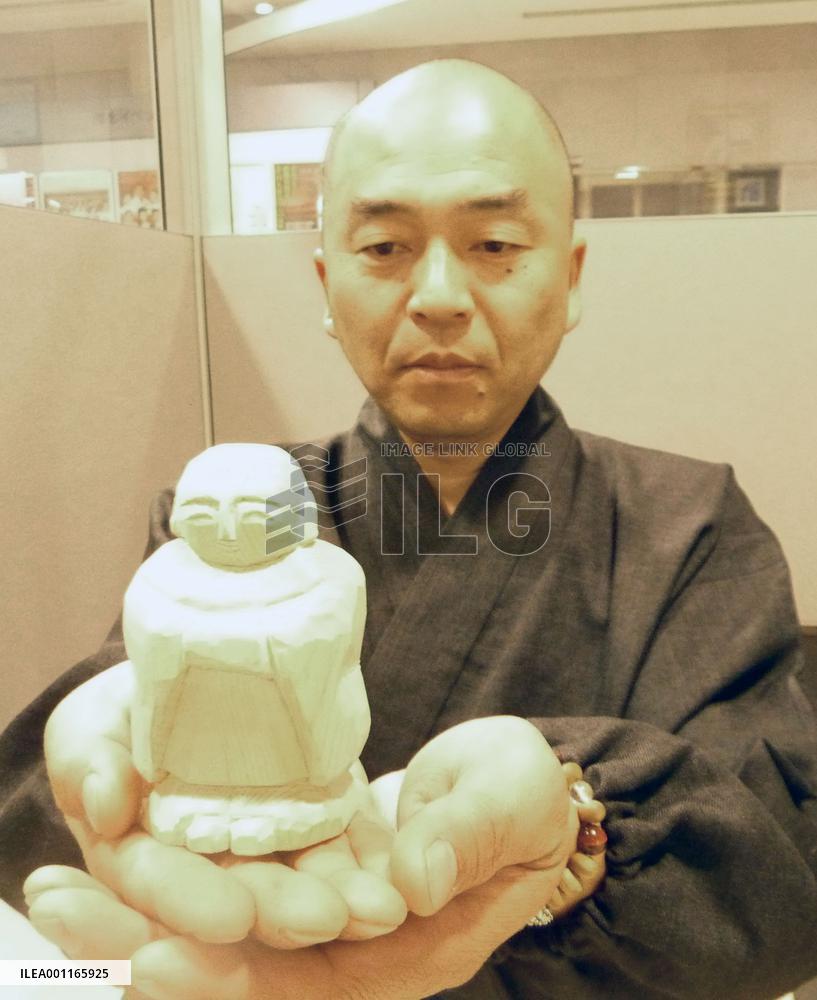 Buddhist monk with jizo deity statue