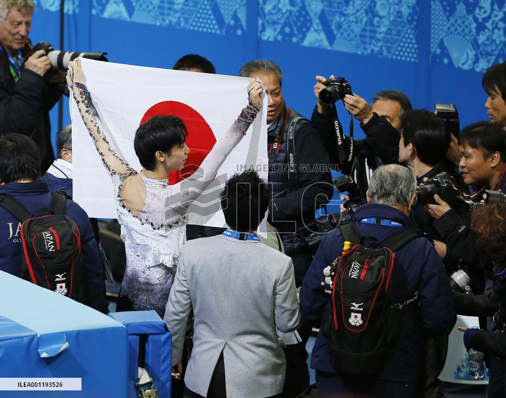 Hanyu hides behind Japanese flag after winning gold in Sochi