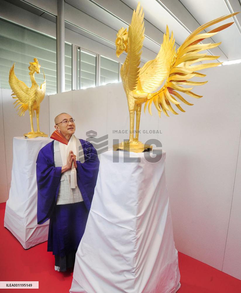 Monk admires golden phoenix statue at Kyoto temple