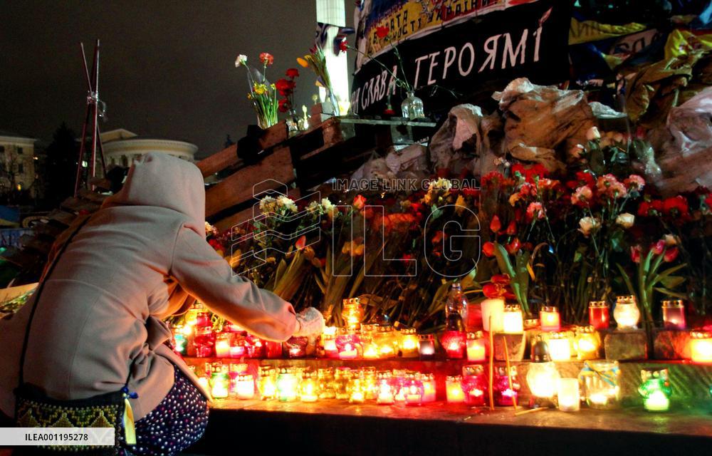 Woman lays candle for victims of violence in Kiev