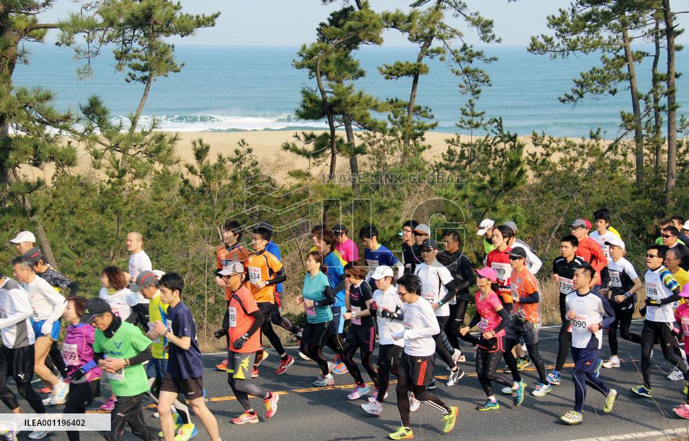 Tottori marathon runners along sand dunes