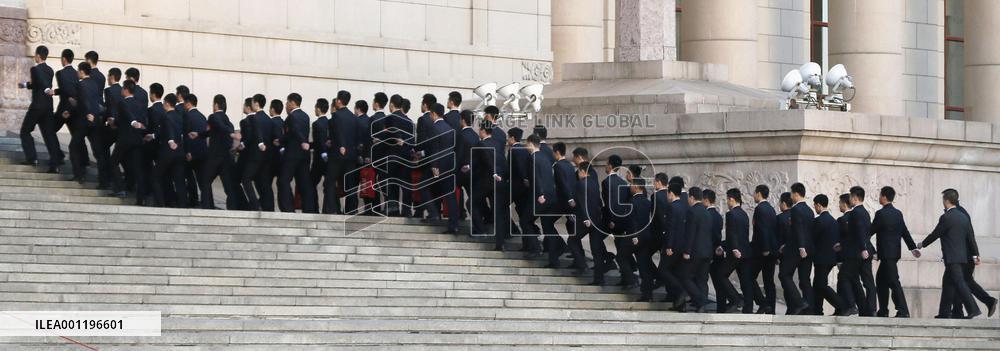 Chinese security officers walk up steps