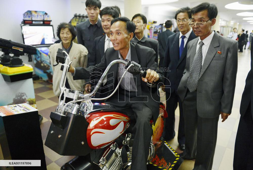 Man plays motorcycle arcade game in Pyongyang