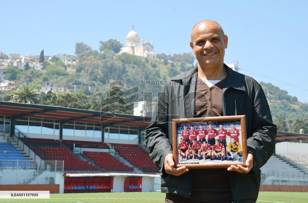 Algerian man holds photo of USM Alger players in 1990s
