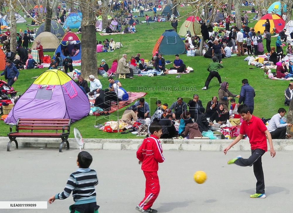 Adults, children relax at park in Tehran