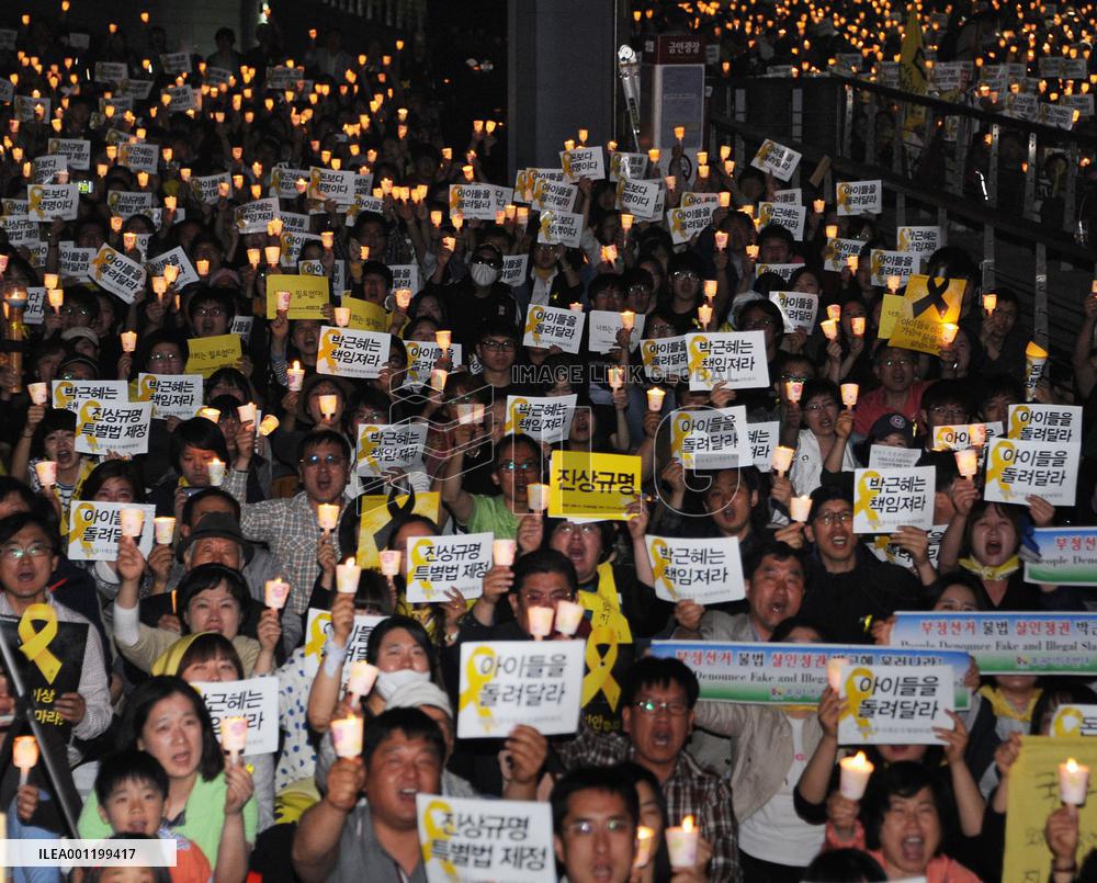 Mourners hold candles at ferry disaster memorial event