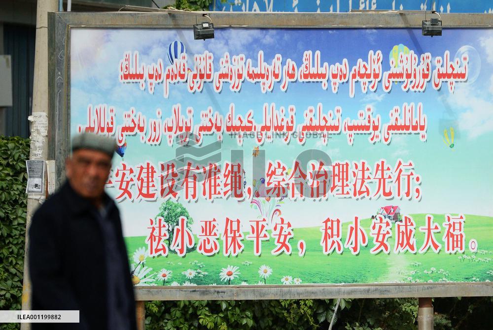Hotan resident passes by anti-crime signboard