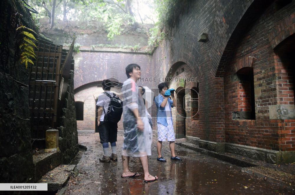 Tourists view gun battery ruins on war island