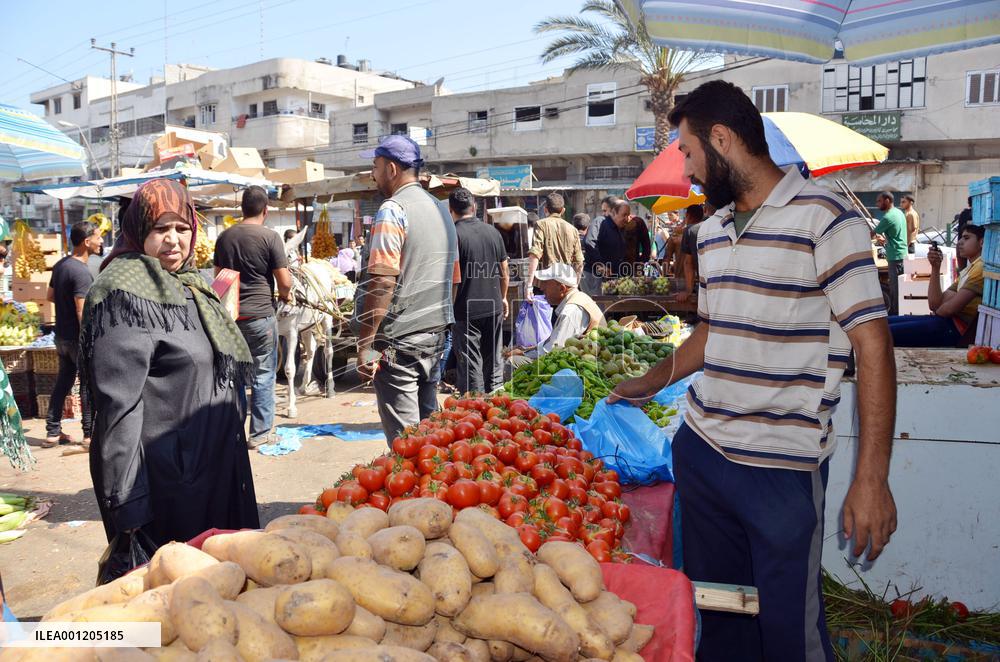 Man sells vegetables in open market in Gaza