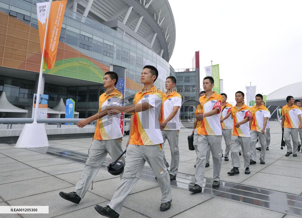 Security officials march around Youth Olympics stadium