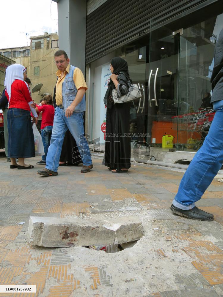 Bomb-created hole remain on shopping street in Damascus
