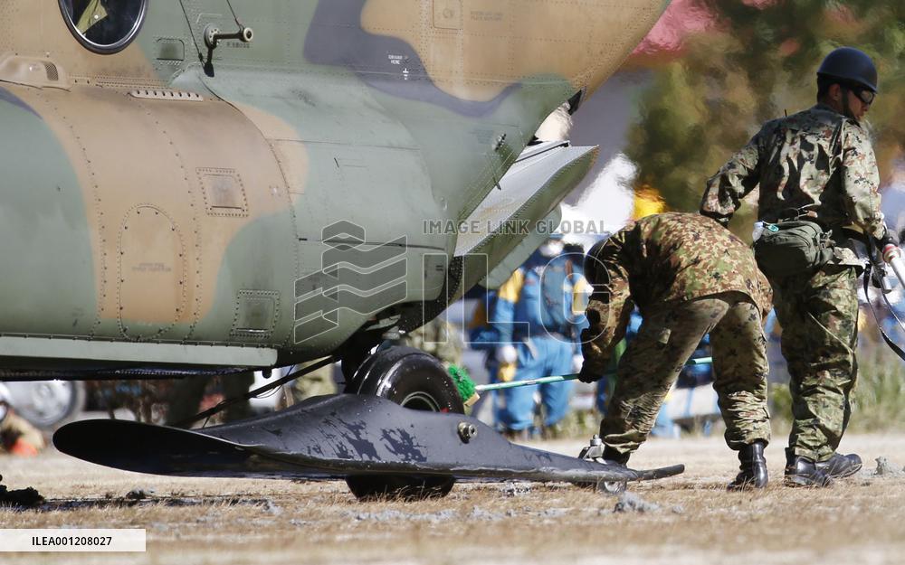 SDF member removes volcanic ash from chopper